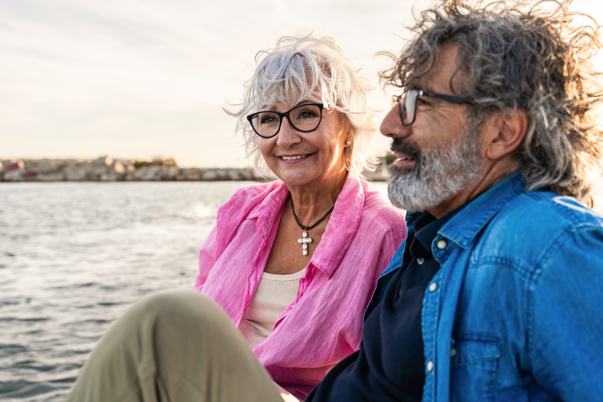 A couple sitting together beside their lake at golden hour