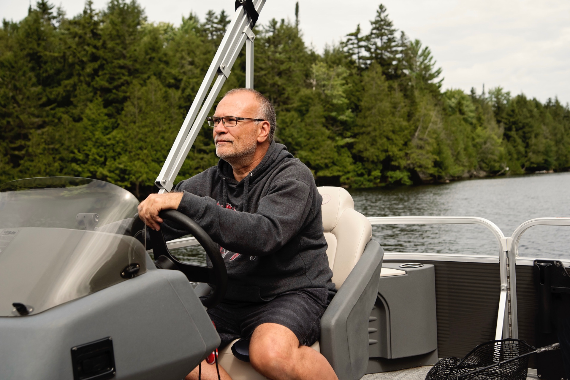Man on a boat holding up a labeled lake water sample bottle
