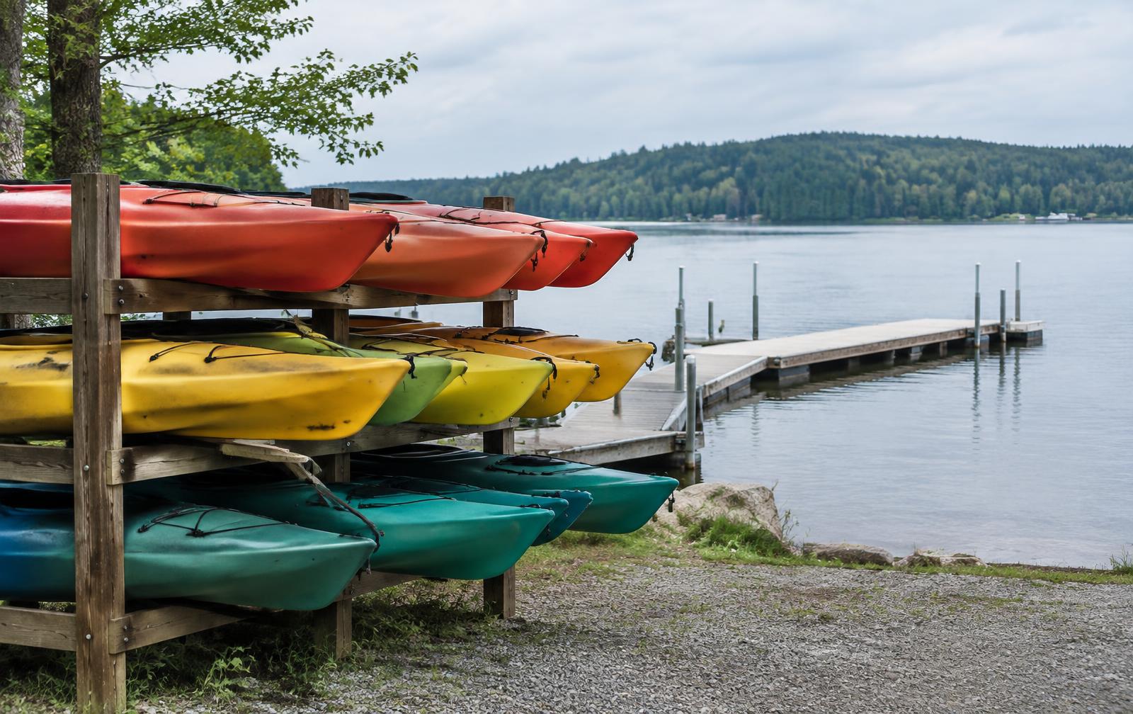 Rental kayaks racked beside a lake dock